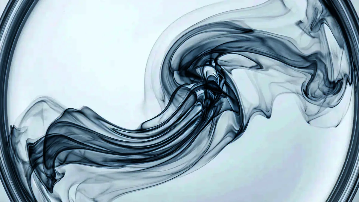 Macro photograph of translucent fluid ribbons swirling and folding through clear water.
