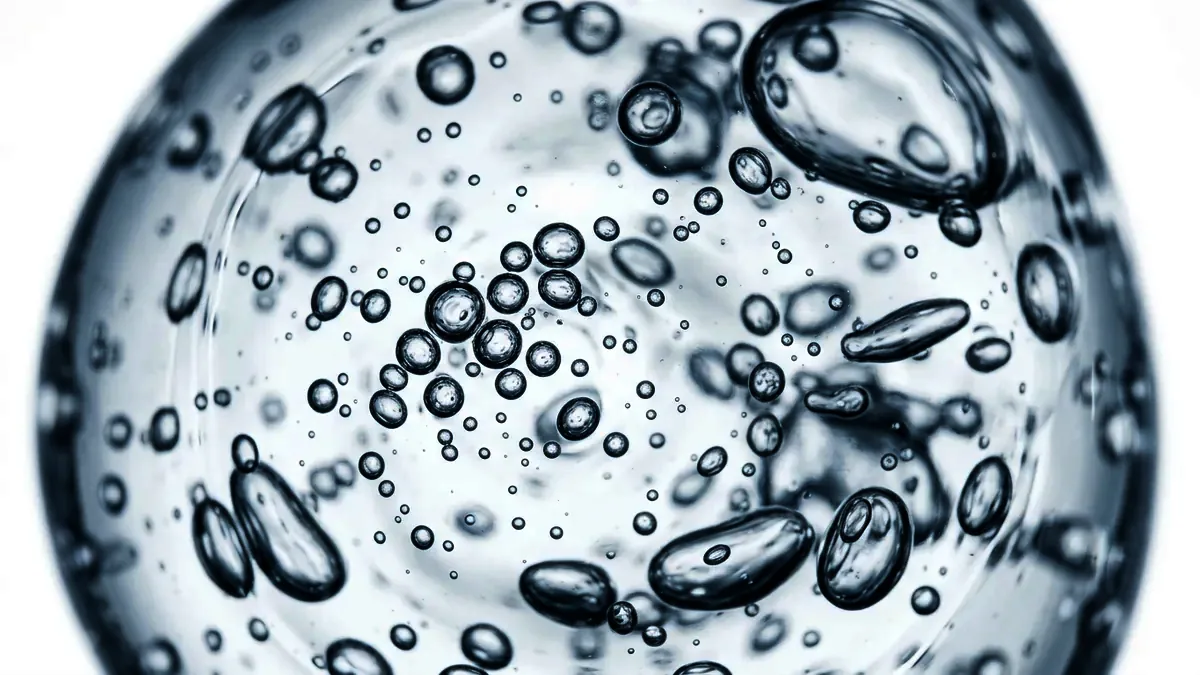 Extreme macro of a smooth clear gel holding tiny suspended bubbles.