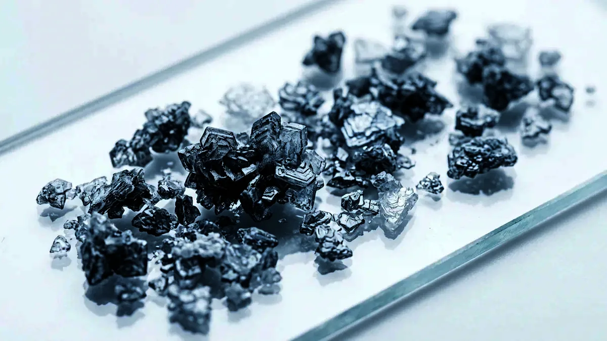 Macro photograph of fine white crystals scattered across a glass slide.