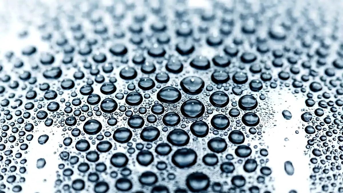 Extreme close-up of condensation beads on a cold glass surface.