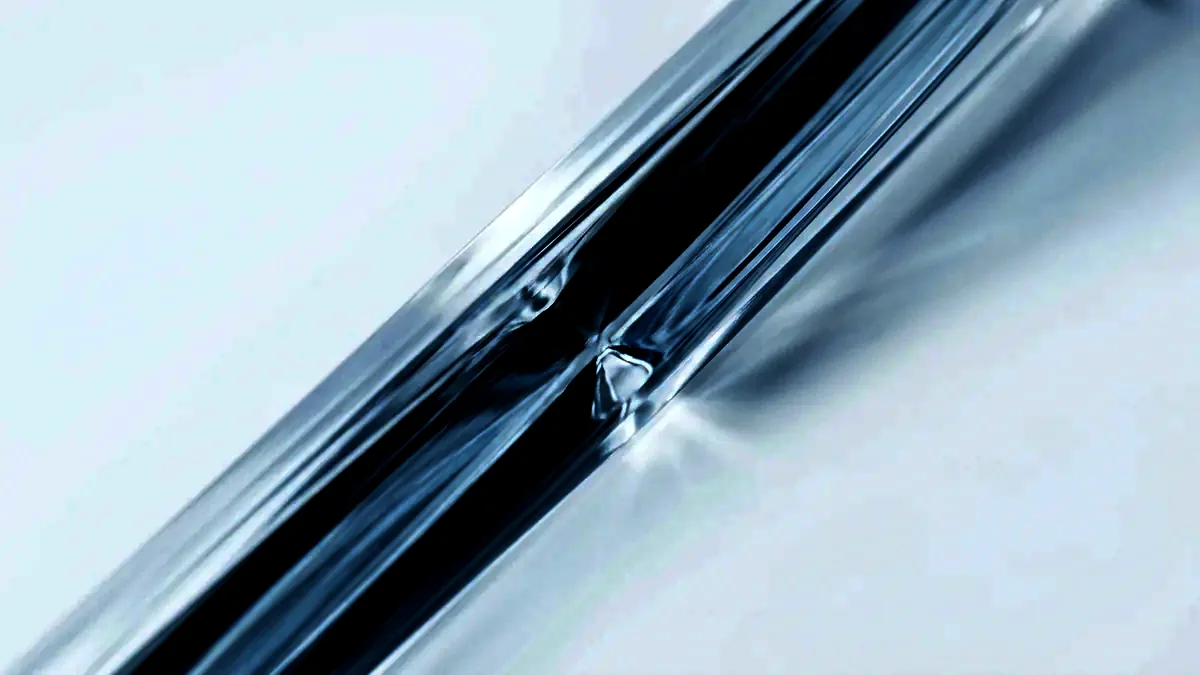 Long refracted streaks of light cast across a white field through clear glass.