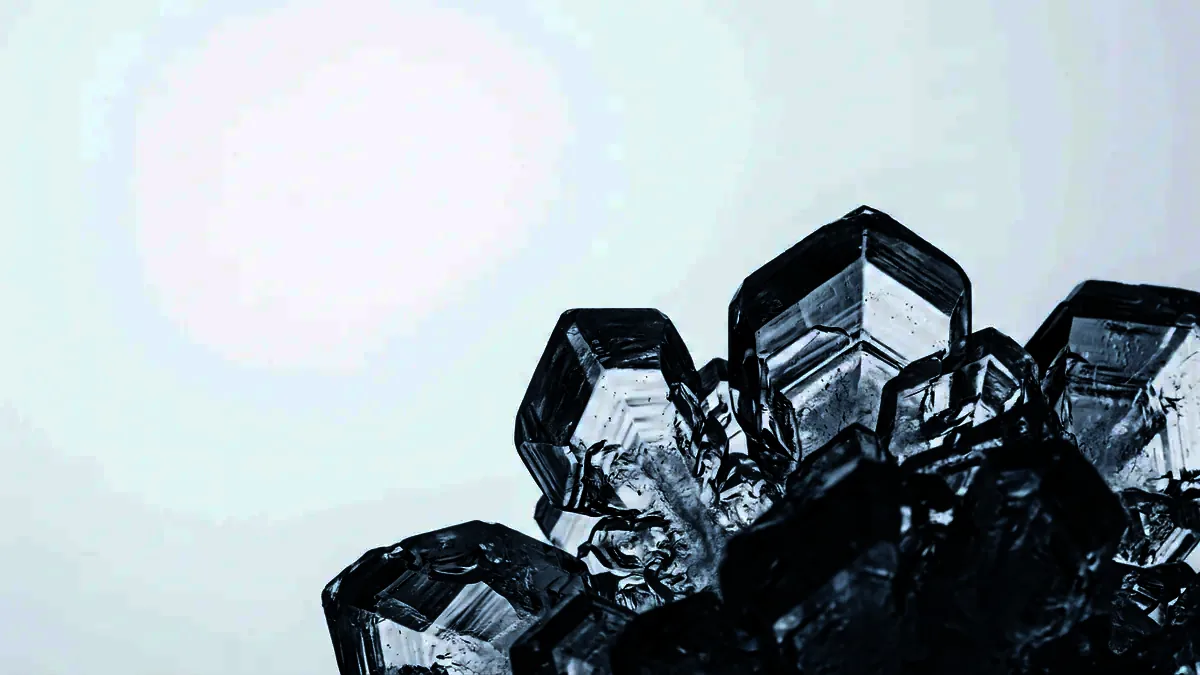 Macro photograph of faceted ice crystals catching cool raking light.